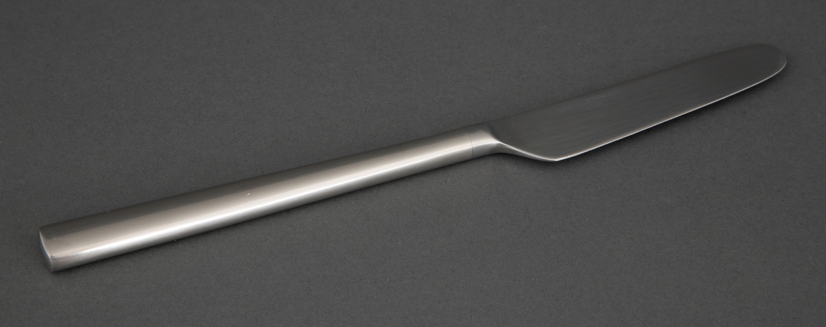 Frokostkniv i presset rustfritt stål med rett linje fra bladrygg til skaft, smalt knivblad og smalt skaft som tiltar noe i bredde og har rett avslutning.