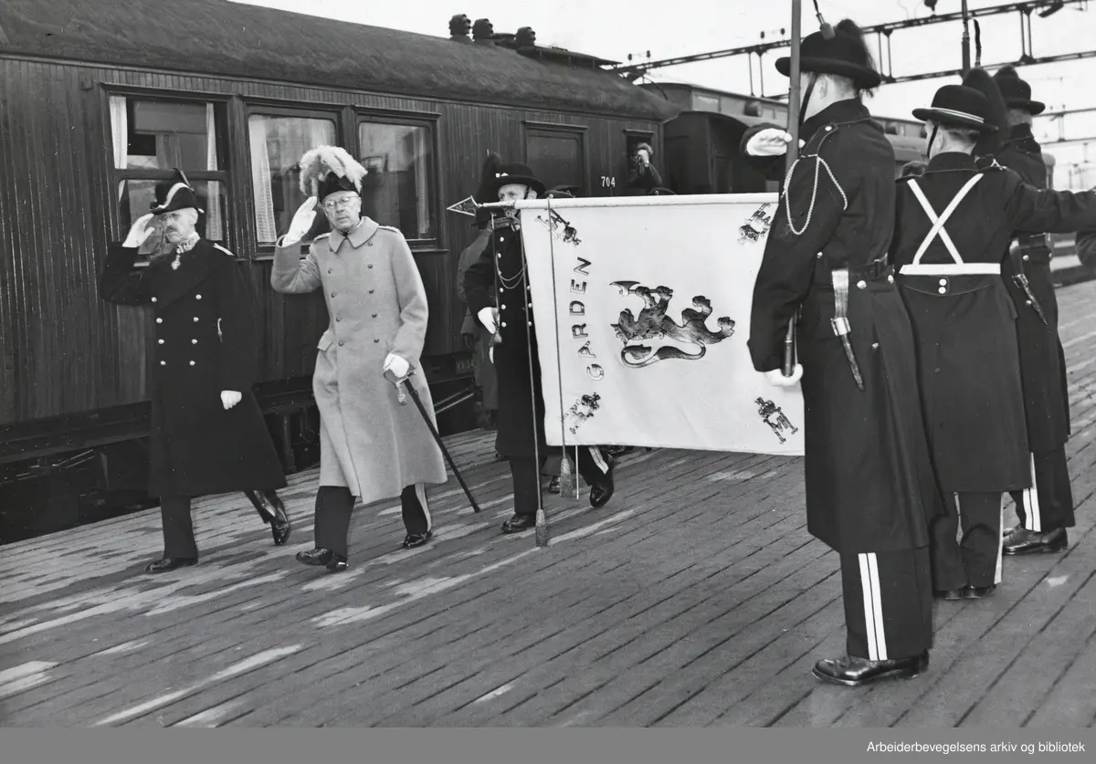 Kong Gustav VI Adolf besøker Oslo. Mars 1952. Mottas på Østbanestasjonen av Kong Haakon VII og Hans Majestet Kongens Garde.