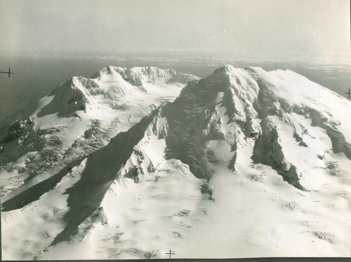 Jan Mayen sommeren 1954.  Navigatøren Jan A.Søstrand  forteller:   Første gangen jeg var på Svalbard var 26. mai 1952 med KKC , kaptein Solem som skipper. Har noen fine bilder av hele mannskapet idet vi stiger opp i båten på Skattøra. Var heldigvis ikke med i 54. Da var jeg på Krigsskolen, men jeg hadde 3 turer til, pluss en tur til Jan Mayen sommeren 54 (ingen flyplass der den gang). Jeg var navigatør. Det var 2 flygere, vanligvis bare 1 navigatør, 1 maskinist, 2 telegrafister. På lengre turer kunne vi være flere. Jeg kan ikke huske datoene på de andre turene. Den ene turen til Ny Ålesund var i forbindelse med gruveulykken der. Vi hadde med medisinsk utstyr som ble droppet på samme måte som med posten. Jeg tok bildet. Jan Mayen turen var i regi av Polarinstituttet og var et rent fotooppdrag. Vi hadde med en professor tror jeg han var som hadde ansvar for fotograferingen, men billdene av vulkanen tok jeg med stort flykamera.