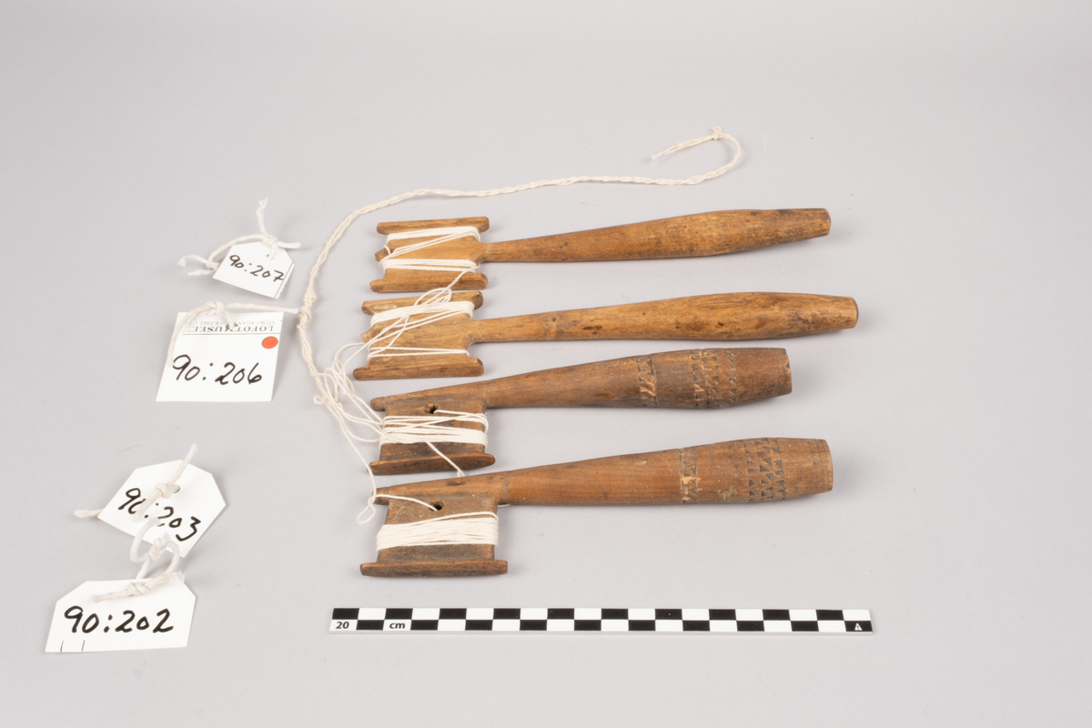 Ett sett slingrestrokker, 4 styker av to varianter, alle er av tre. To av stokkene er med dekorert håndtak og enkeltside hode for anleggelse av tråd. Hullet er plassert inn mot stokken omtrent midt på hodets lengde. Håndtaket er har et tilnærmet ovalt tverrsnitt som smalner ut mot hodet og mot den butte nedre enden. Håndtaket er dekorert med omgivende geometrisk dekor utgjort av trekanter som er skåret ut av treverket, samt tre linjer nederst på håndtaket. De to siste stokkene er med dobbelt hode for anleggelse av tråd på begge sider av stokken. Hullet er plassert mot enden, midt mellom utsvingingen av hodene. Håndtakene er uten dekor og har et tilnærmet ovalt tverrsnitt som smalner ut mot hodet og mot den butte nedre enden. De fire stokkene henger sammen via et påbegynt slingring stykke med bomullstråd.