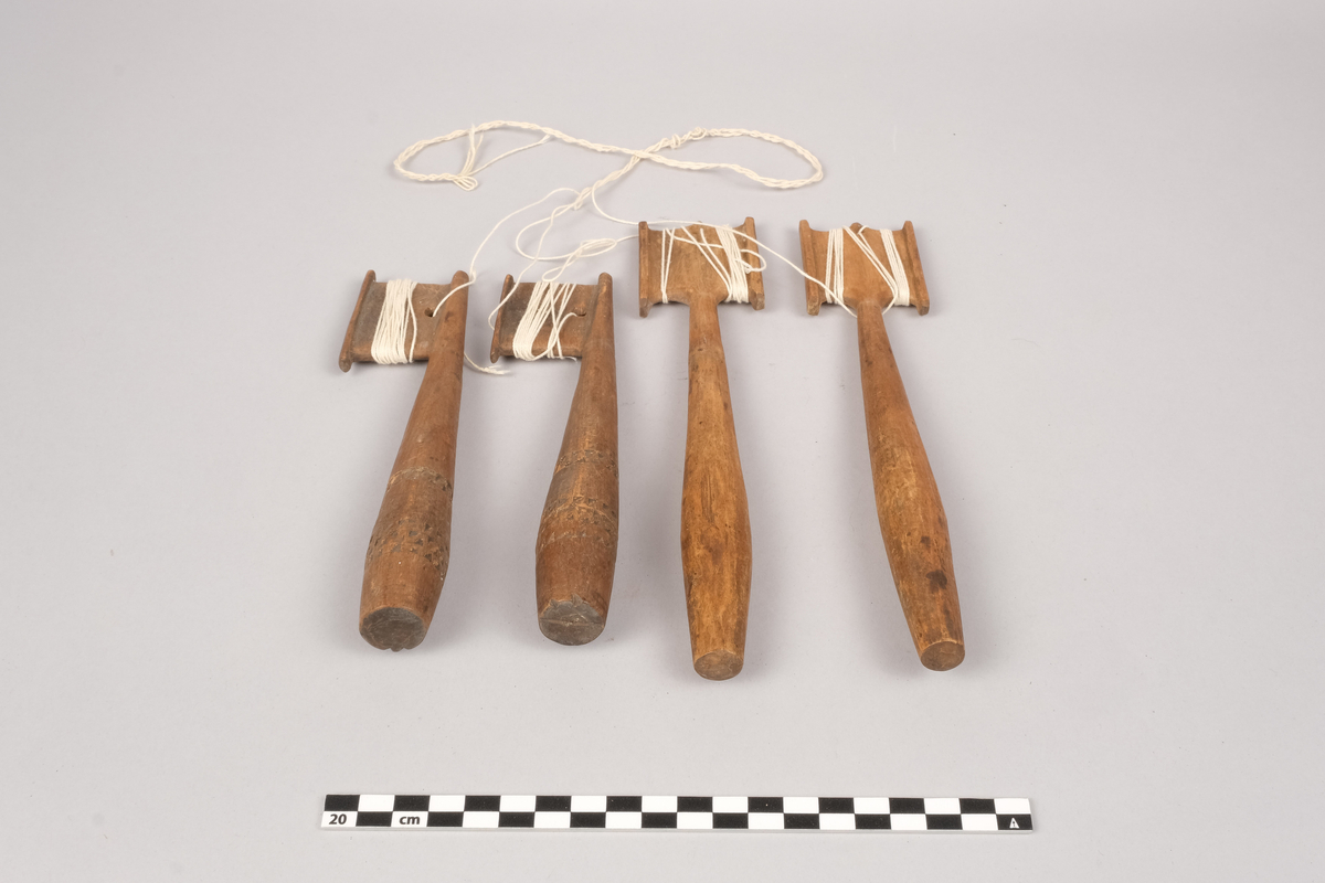 Ett sett slingrestrokker, 4 styker av to varianter, alle er av tre. To av stokkene er med dekorert håndtak og enkeltside hode for anleggelse av tråd. Hullet er plassert inn mot stokken omtrent midt på hodets lengde. Håndtaket er har et tilnærmet ovalt tverrsnitt som smalner ut mot hodet og mot den butte nedre enden. Håndtaket er dekorert med omgivende geometrisk dekor utgjort av trekanter som er skåret ut av treverket, samt tre linjer nederst på håndtaket. De to siste stokkene er med dobbelt hode for anleggelse av tråd på begge sider av stokken. Hullet er plassert mot enden, midt mellom utsvingingen av hodene. Håndtakene er uten dekor og har et tilnærmet ovalt tverrsnitt som smalner ut mot hodet og mot den butte nedre enden. De fire stokkene henger sammen via et påbegynt slingring stykke med bomullstråd.