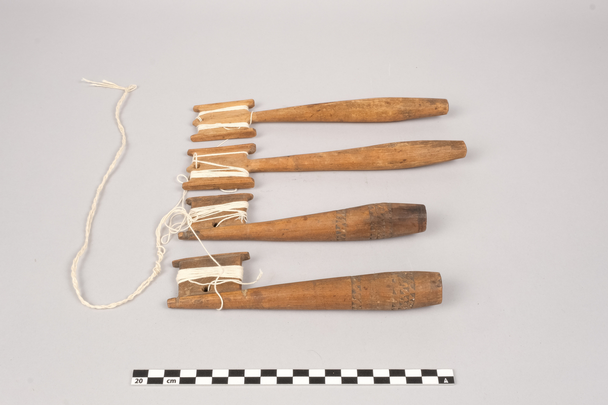 Ett sett slingrestrokker, 4 styker av to varianter, alle er av tre. To av stokkene er med dekorert håndtak og enkeltside hode for anleggelse av tråd. Hullet er plassert inn mot stokken omtrent midt på hodets lengde. Håndtaket er har et tilnærmet ovalt tverrsnitt som smalner ut mot hodet og mot den butte nedre enden. Håndtaket er dekorert med omgivende geometrisk dekor utgjort av trekanter som er skåret ut av treverket, samt tre linjer nederst på håndtaket. De to siste stokkene er med dobbelt hode for anleggelse av tråd på begge sider av stokken. Hullet er plassert mot enden, midt mellom utsvingingen av hodene. Håndtakene er uten dekor og har et tilnærmet ovalt tverrsnitt som smalner ut mot hodet og mot den butte nedre enden. De fire stokkene henger sammen via et påbegynt slingring stykke med bomullstråd.