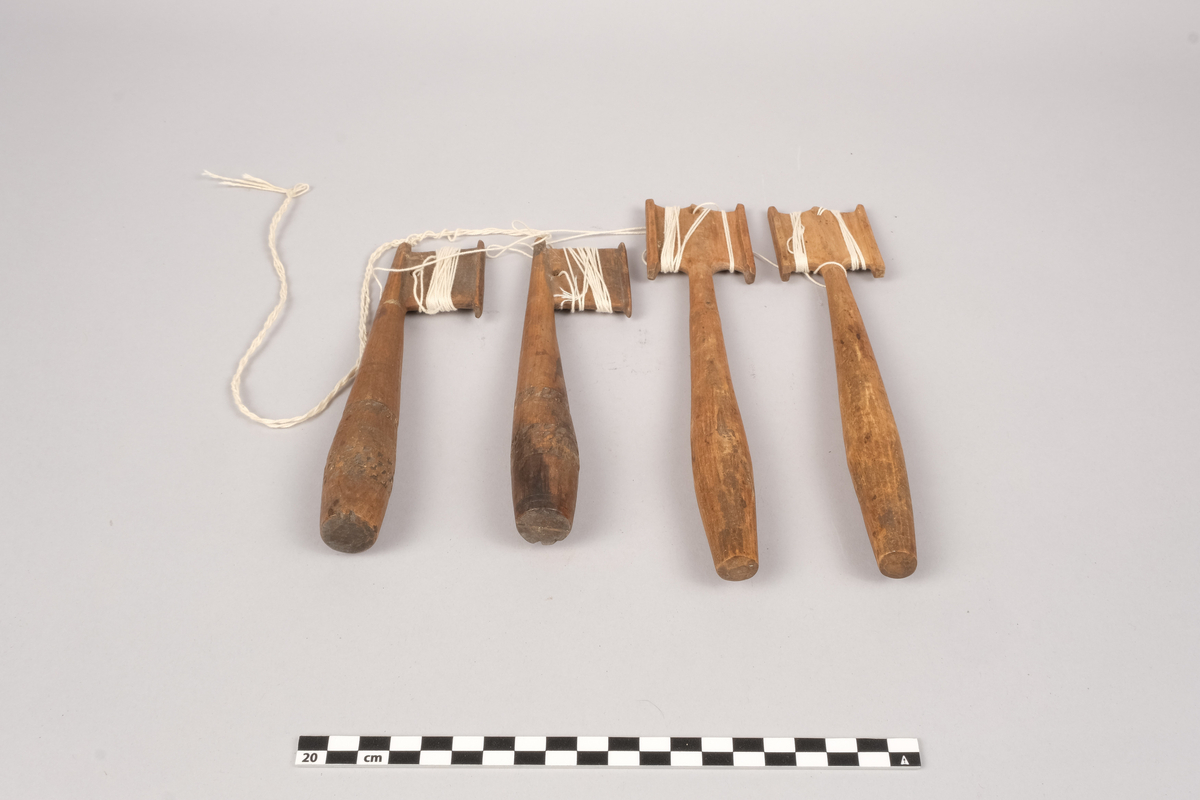Ett sett slingrestrokker, 4 styker av to varianter, alle er av tre. To av stokkene er med dekorert håndtak og enkeltside hode for anleggelse av tråd. Hullet er plassert inn mot stokken omtrent midt på hodets lengde. Håndtaket er har et tilnærmet ovalt tverrsnitt som smalner ut mot hodet og mot den butte nedre enden. Håndtaket er dekorert med omgivende geometrisk dekor utgjort av trekanter som er skåret ut av treverket, samt tre linjer nederst på håndtaket. De to siste stokkene er med dobbelt hode for anleggelse av tråd på begge sider av stokken. Hullet er plassert mot enden, midt mellom utsvingingen av hodene. Håndtakene er uten dekor og har et tilnærmet ovalt tverrsnitt som smalner ut mot hodet og mot den butte nedre enden. De fire stokkene henger sammen via et påbegynt slingring stykke med bomullstråd.