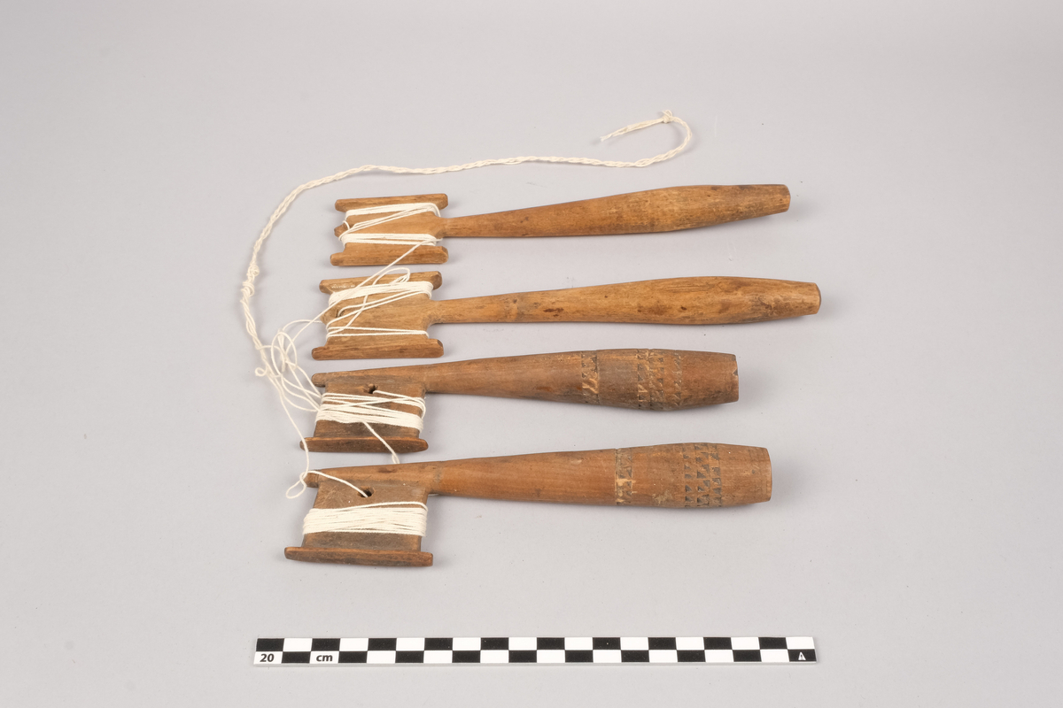 Ett sett slingrestrokker, 4 styker av to varianter, alle er av tre. To av stokkene er med dekorert håndtak og enkeltside hode for anleggelse av tråd. Hullet er plassert inn mot stokken omtrent midt på hodets lengde. Håndtaket er har et tilnærmet ovalt tverrsnitt som smalner ut mot hodet og mot den butte nedre enden. Håndtaket er dekorert med omgivende geometrisk dekor utgjort av trekanter som er skåret ut av treverket, samt tre linjer nederst på håndtaket. De to siste stokkene er med dobbelt hode for anleggelse av tråd på begge sider av stokken. Hullet er plassert mot enden, midt mellom utsvingingen av hodene. Håndtakene er uten dekor og har et tilnærmet ovalt tverrsnitt som smalner ut mot hodet og mot den butte nedre enden. De fire stokkene henger sammen via et påbegynt slingring stykke med bomullstråd.