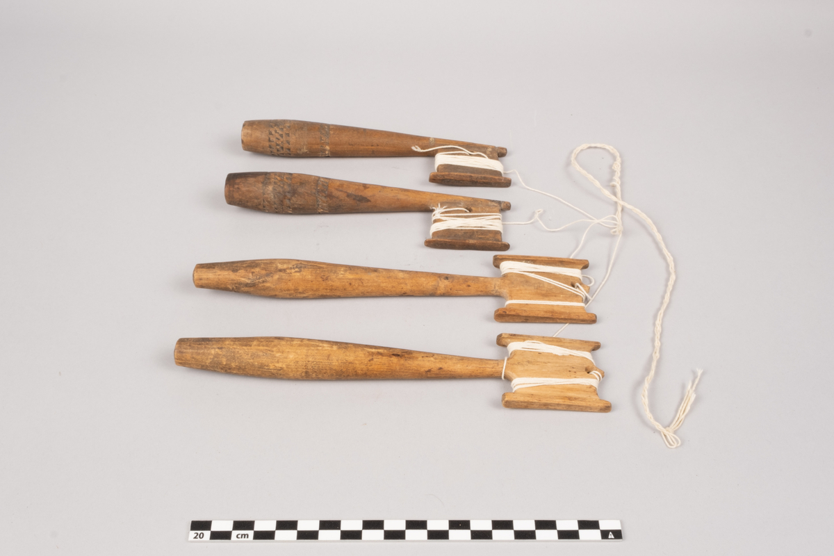 Ett sett slingrestrokker, 4 styker av to varianter, alle er av tre. To av stokkene er med dekorert håndtak og enkeltside hode for anleggelse av tråd. Hullet er plassert inn mot stokken omtrent midt på hodets lengde. Håndtaket er har et tilnærmet ovalt tverrsnitt som smalner ut mot hodet og mot den butte nedre enden. Håndtaket er dekorert med omgivende geometrisk dekor utgjort av trekanter som er skåret ut av treverket, samt tre linjer nederst på håndtaket. De to siste stokkene er med dobbelt hode for anleggelse av tråd på begge sider av stokken. Hullet er plassert mot enden, midt mellom utsvingingen av hodene. Håndtakene er uten dekor og har et tilnærmet ovalt tverrsnitt som smalner ut mot hodet og mot den butte nedre enden. De fire stokkene henger sammen via et påbegynt slingring stykke med bomullstråd.