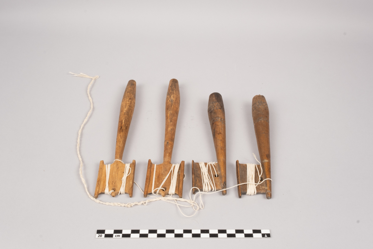 Ett sett slingrestrokker, 4 styker av to varianter, alle er av tre. To av stokkene er med dekorert håndtak og enkeltside hode for anleggelse av tråd. Hullet er plassert inn mot stokken omtrent midt på hodets lengde. Håndtaket er har et tilnærmet ovalt tverrsnitt som smalner ut mot hodet og mot den butte nedre enden. Håndtaket er dekorert med omgivende geometrisk dekor utgjort av trekanter som er skåret ut av treverket, samt tre linjer nederst på håndtaket. De to siste stokkene er med dobbelt hode for anleggelse av tråd på begge sider av stokken. Hullet er plassert mot enden, midt mellom utsvingingen av hodene. Håndtakene er uten dekor og har et tilnærmet ovalt tverrsnitt som smalner ut mot hodet og mot den butte nedre enden. De fire stokkene henger sammen via et påbegynt slingring stykke med bomullstråd.