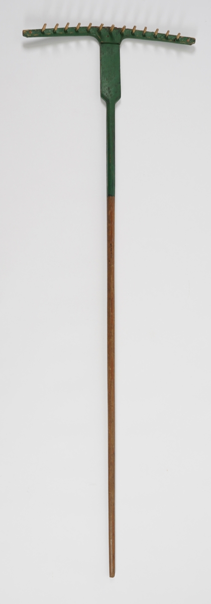 Rive i tre. Tindane er òg av tre. Det har vore 15 tindar, men det er knekt av ein tind på kvar ende. Hovudet og nedre del av skaftet er grønmåla.