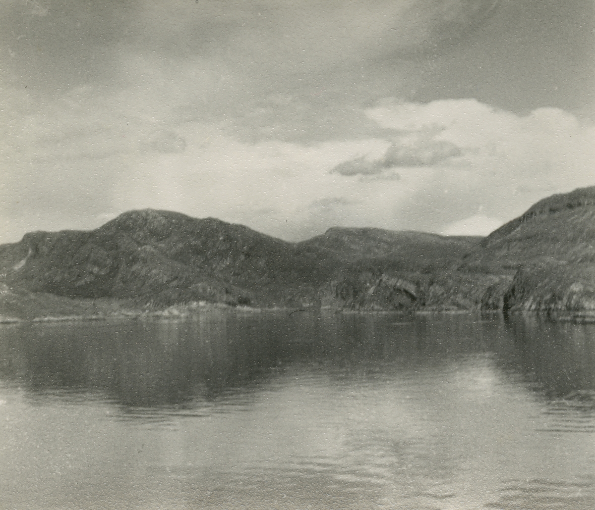 Bildet kommer fra The Cambridge Spitsbergen Expedition. Ekspedisjonen besto av seks menn, de fleste var geomorfologer, som dro fra England til Svalbard via Nordkapp og Bjørnøya om bord på Lyngen sommeren 1938. Målet deres var å kartlegge området rundt Nordenskioldbreen, Gipsvika og Brucebyen. Bildetekst på baksiden: Near Bodø.