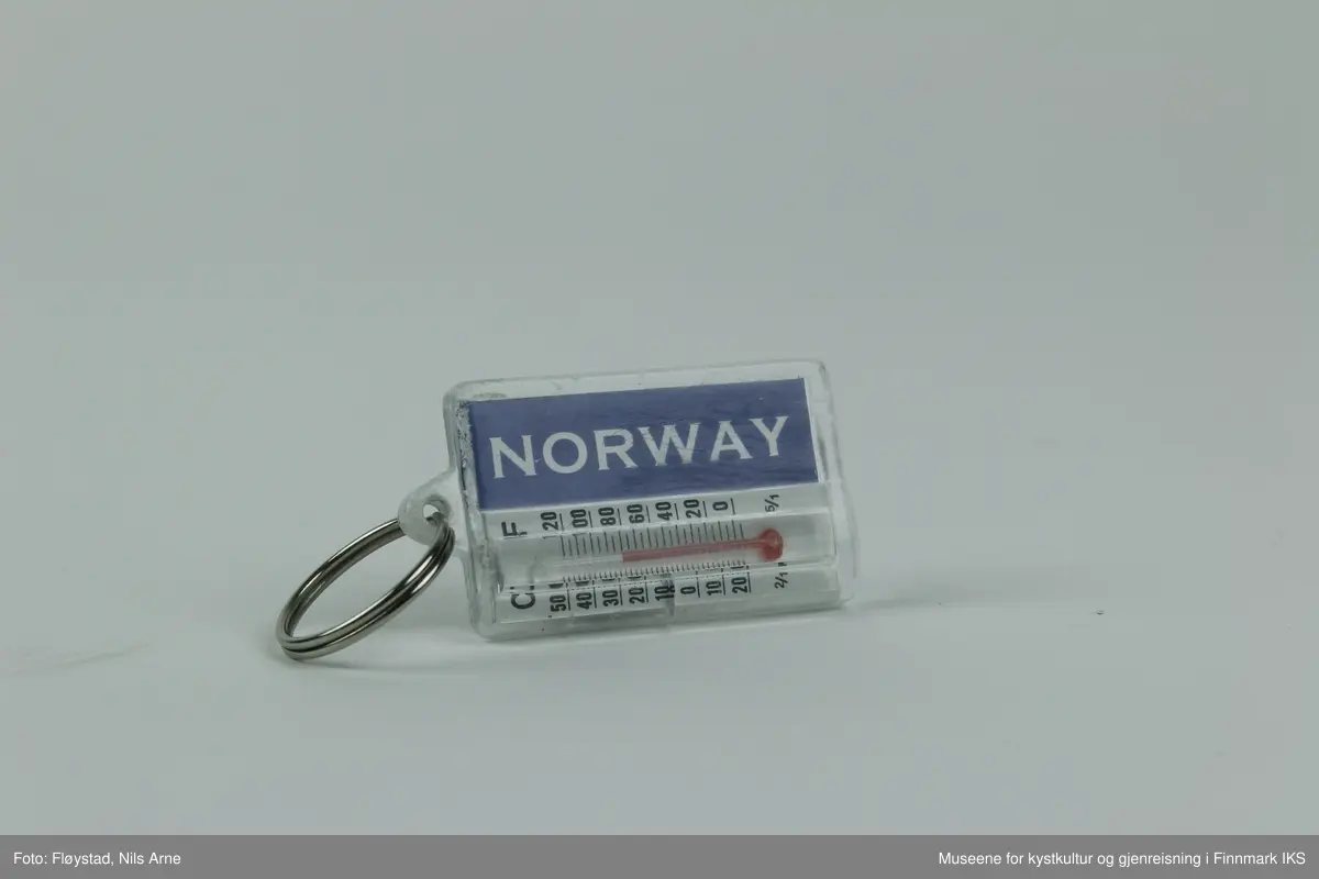 En nøkkelring festet i en rektangulær brikke med dekor og en gradestokk. 

Brikken er laget av pleksiglass eller akrylglass (PMMA), dekorert med et trykt fotomotiv på framsiden. Fotomotivet er av Nordkapp-globusen og en lettskyet, solrik himmel i bakgrunnen. Under motivet av globusen er det trykt "NORDKAPP 71°10'21" i hvitt.  Det er satt inn en liten gradestokk på baksiden av brikken som viser temperaturen i både Celsius ig Fahrenheit. Ved siden av gradestokken er "NORWAY" trykt i hvitt på en mørkeblå bakgrunn.