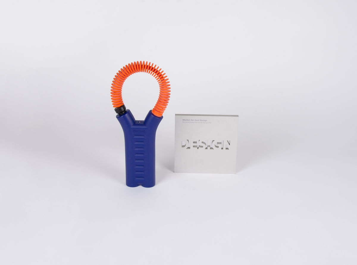 Batteristarter med blå batteridel med sirkelformet, fleksibel kabel.

Kvadratisk designpris i børstet alluminium med utskåret tekst: Design. Øvrig tekst påtrykket.