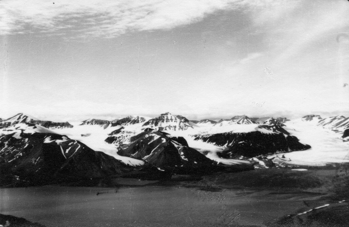 Utsikt mot Petuniabukta fra Wordiekammen. Bildet kommer fra The Cambridge Spitsbergen Expedition. Ekspedisjonen besto av seks menn, de fleste var geomorfologer, som dro fra England til Svalbard via Nordkapp og Bjørnøya om bord på Lyngen sommeren 1938. Målet deres var å kartlegge området rundt Nordenskioldbreen, Gipsvika og Brucebyen.