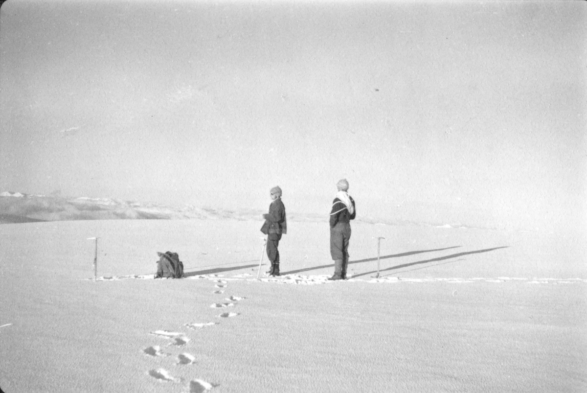 To menn på et snødekket fjell. Bildet kommer fra The Cambridge Spitsbergen Expedition. Ekspedisjonen besto av seks menn, de fleste var geomorfologer, som dro fra England til Svalbard via Nordkapp og Bjørnøya om bord på Lyngen sommeren 1938. Målet deres var å kartlegge området rundt