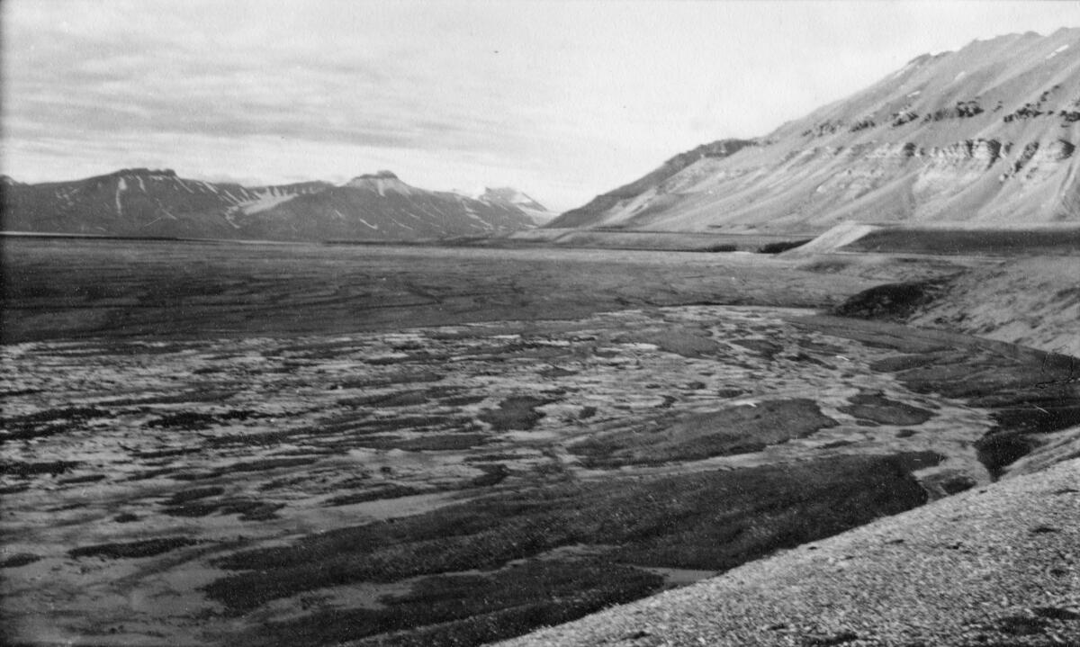 Kapp Ekholm. Bildet kommer fra The Cambridge Spitsbergen Expedition. Ekspedisjonen besto av seks menn, de fleste var geomorfologer, som dro fra England til Svalbard via Nordkapp og Bjørnøya om bord på Lyngen sommeren 1938. Målet deres var å kartlegge området rundt Nordenskioldbreen, Gipsvika og Brucebyen.