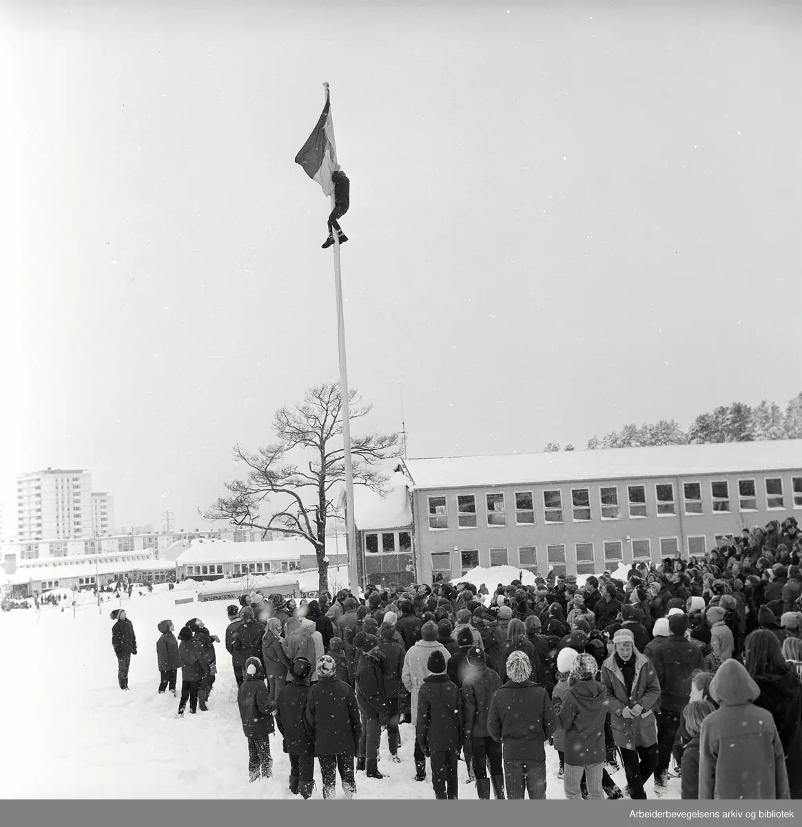Demonstrasjon mot krigen i Vietnam. FNL-flagget (den nasjonale frigjøringsfronten for Sør-Vietnam) heises på Manglerud skole. Februar 1968