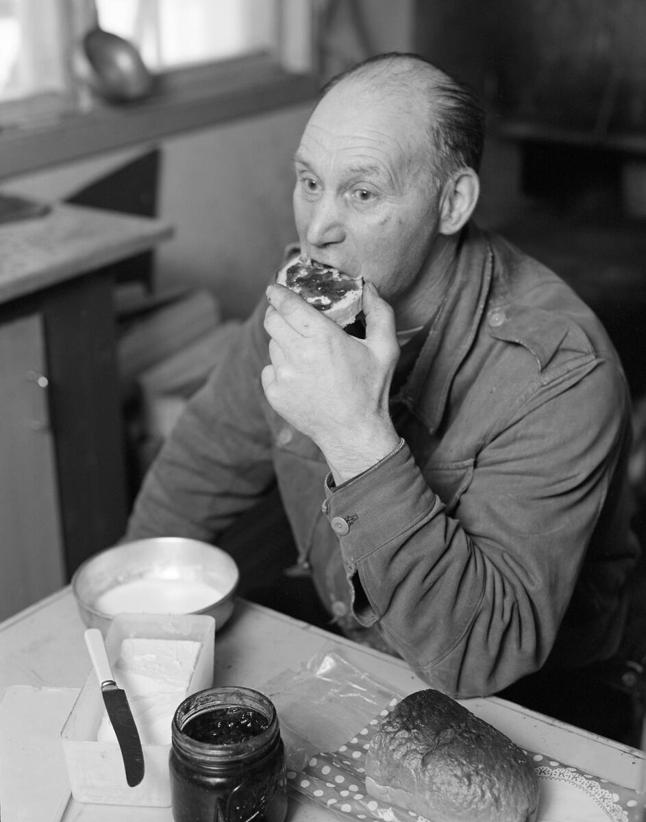 Skogsarbeider Johan Rasch spiser frokost i Smaltjernkoia i Svartholtet, Elverum, Hedmark i januar 1975.