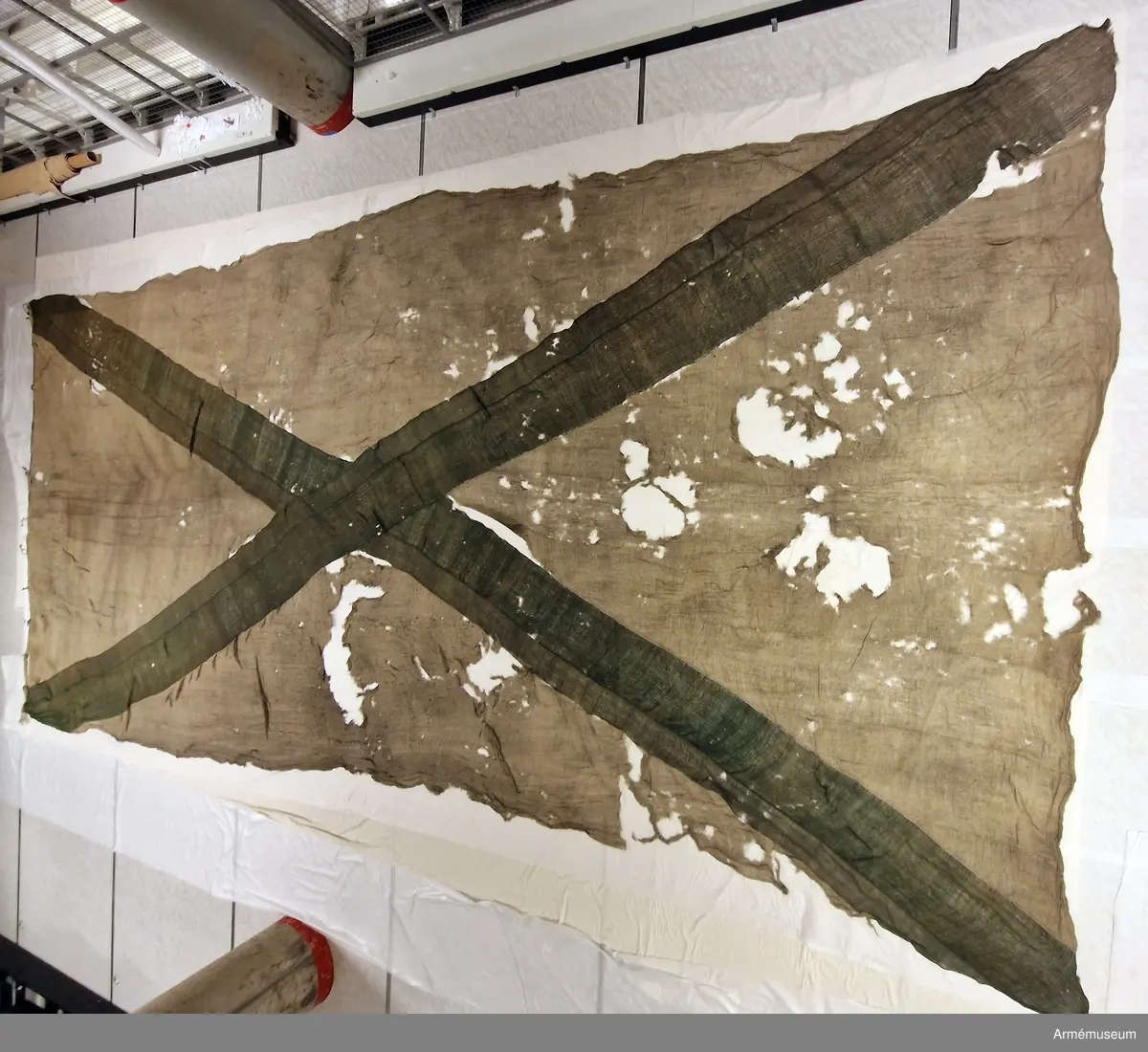 Flagga av flaggduk, sydd av 11 våder vitt tyg samt två våder blått i ett S:t Andreaskors. Vid stångsidan en förstärkning med snören som ska fästa flaggan i riggen. Även själva flaggan är förstärkt med extra lager blått tyg närmast stångsidan.
Etikett av pergament med text: "No 3. Flagg, Tagen uti Sjöslaget emellan den Swenske och Ryske Flottan, under Kalkbåds Grunden, d. 17 Julii 1788. Swenska Flottan, under hans Kongl. Höghets Hertig Carls af Södermanland Öfwerbefäl, bestod då af femton Linie-Skepp och fem Fregatter: Den Ryske under Amiral Greighs af 33 Segel, hwaraf woro: en Tredäckare, åtta 74 och åtta 66 kanon-skepp, samt 7 Stora Fregatter. Som utom fördel af winden, war till en tredjedel starkare armerad, med en för längre tid beredd kostsam utrustning och et swårt Artillerie."