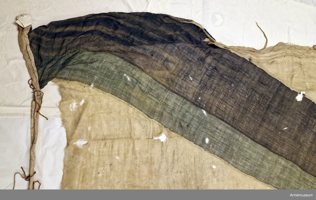 Flagga av flaggduk, sydd av 11 våder vitt tyg samt två våder blått i ett S:t Andreaskors. Vid stångsidan en förstärkning med snören som ska fästa flaggan i riggen. Även själva flaggan är förstärkt med extra lager blått tyg närmast stångsidan. Runt duken har det suttit en förstärkning i form av ett insytt snöre.