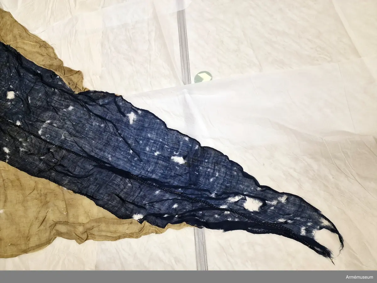 Tvåtungad standert av flaggduk, sydd av 12 våder vitt tyg samt två våder blått i ett S:t Andreaskors. Vid stångsidan en förstärkning med snören som ska fästa flaggan i riggen, förstärkningen försedd med kyrilliska bokstäver. Även själva standerten är förstärkt med extra lager blått tyg närmast stångsidan.
Etikett av pergament med svårtydd text "(...) 9. juli 1790, No 2".