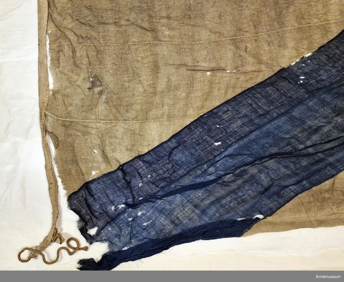 Tvåtungad standert av flaggduk, sydd av 12 våder vitt tyg samt två våder blått i ett S:t Andreaskors. Vid stångsidan en förstärkning med snören som ska fästa flaggan i riggen, förstärkningen försedd med kyrilliska bokstäver. Även själva standerten är förstärkt med extra lager blått tyg närmast stångsidan.
Etikett av pergament med svårtydd text "(...) 9. juli 1790, No 2".
