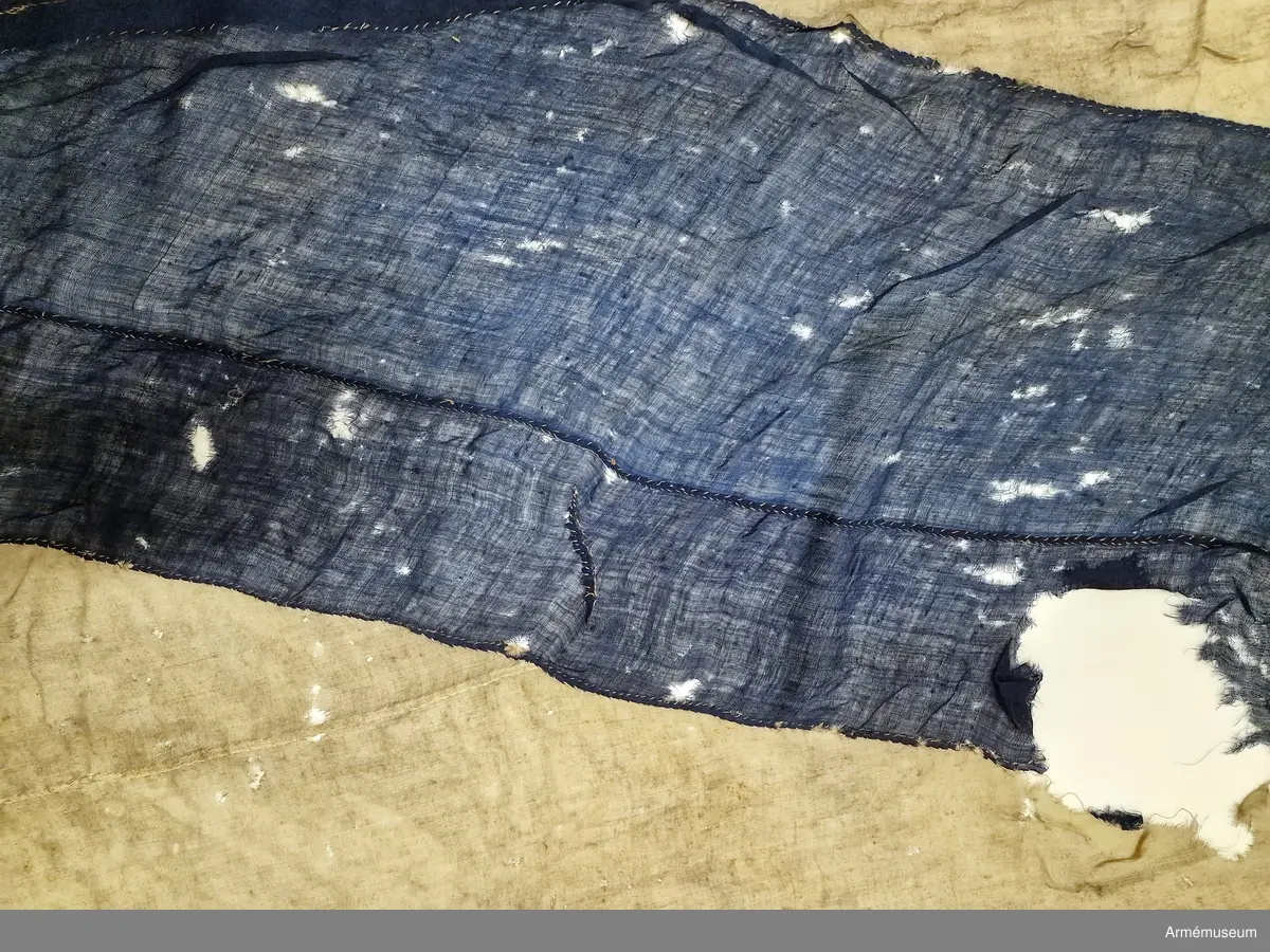 Tvåtungad standert av flaggduk, sydd av 12 våder vitt tyg samt två våder blått i ett S:t Andreaskors. Vid stångsidan en förstärkning med snören som ska fästa flaggan i riggen, förstärkningen försedd med kyrilliska bokstäver. Även själva standerten är förstärkt med extra lager blått tyg närmast stångsidan.
Etikett av pergament med svårtydd text "(...) 9. juli 1790, No 2".