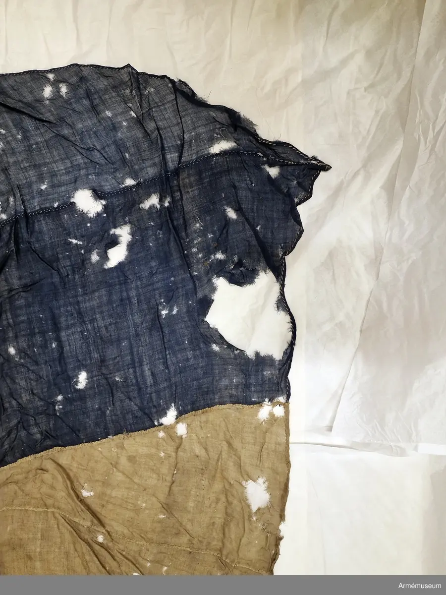 Flagga av flaggduk, sydd av 11 våder vitt tyg samt två våder blått i ett S:t Andreaskors. Vid stångsidan en förstärkning med snören som ska fästa flaggan i riggen. Även själva flaggan är förstärkt med extra lager blått tyg närmast stångsidan. En liten symbol broderad i vitt på det blå fältet.
Etikett av pergament med text: "No 19, Denna Ryska Flagga 11 Duk, är tagen uti Bataillen vid Svensksund under Hans Kungl. Maj:ts Egit Höga Befäl och Anförande 9. Juli 1790".