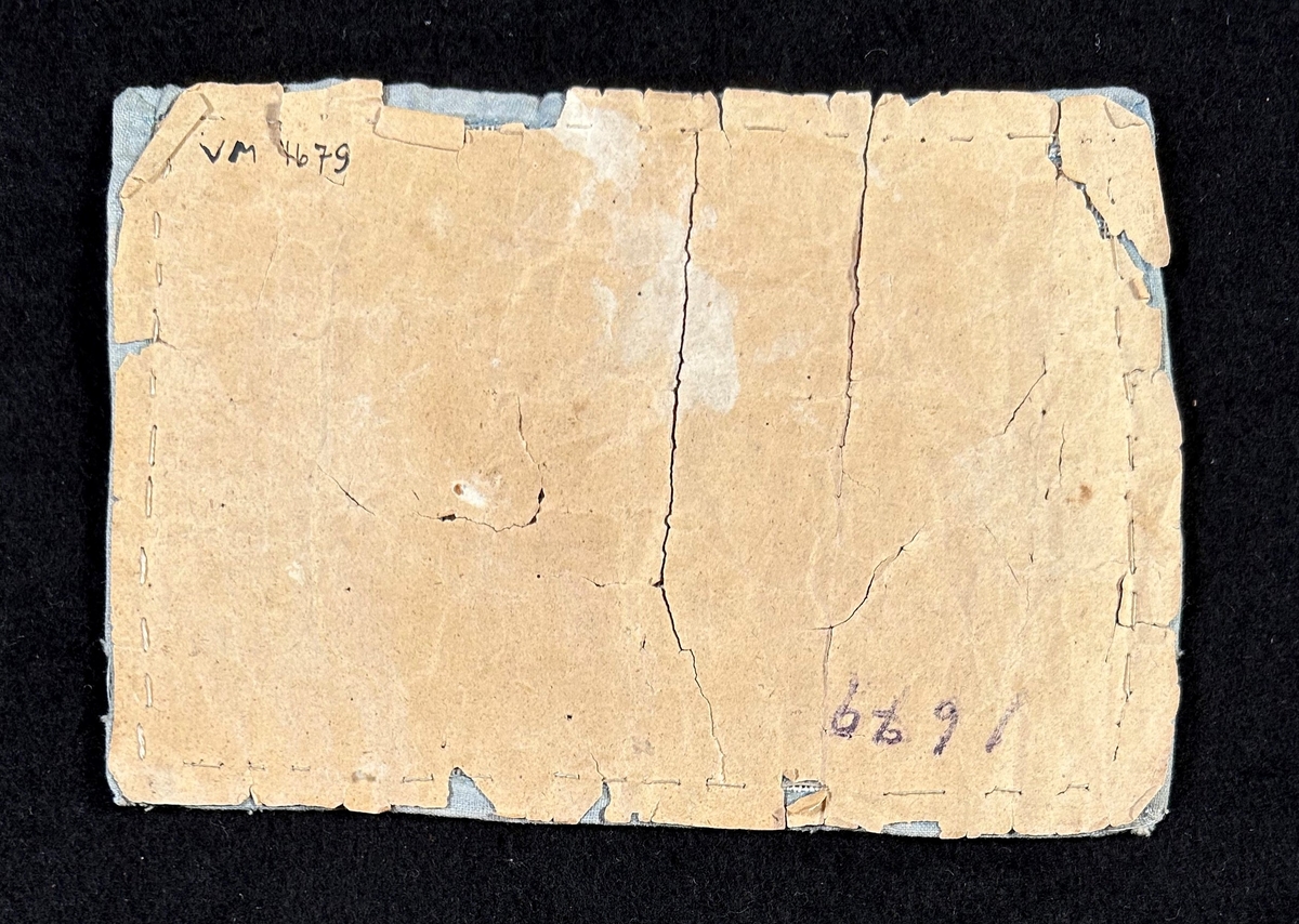 Märkduk av tuskaftat linne, sydd med korssöm. Alfabetet i mitten , bård runt om i rosa och ljusblått. Kantad med ljusblått tuskaftad bomull. Uppfodrad och fastsydd på papper.