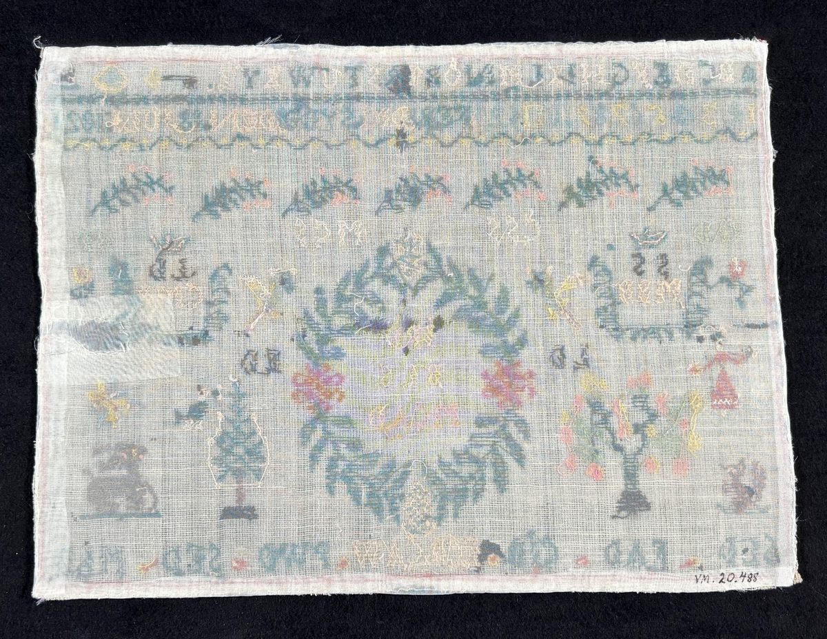 Märkduk i symmetrisk komposition. Överst två rader med alfabetet och siffror. På den undre raden står "Ferdigsydd den 18 juli 1821." I mitten en oval krans med monogram; JPD, BLLS, MCAD, på båda sior två par krönta monogram SS, MBB LD, CMB. Längst ned en rad med olika monogram; SLD, FAD, CJD, ECB, CAW, PWD, SED, MLD. För övrigt växt- och djurmotiv. Monterad på papper.