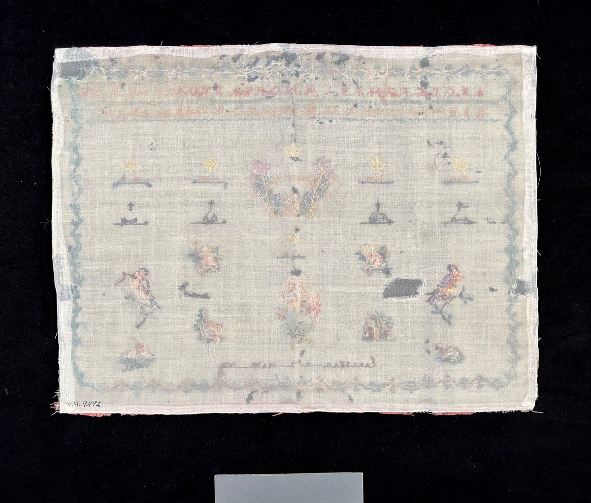 Märkduk på botten av ofärgad appreterad ylle. Korsstygngsbroderi i pastellfärger; blått, rosa, och brunt. Bård rut om. Upptill två rader med alfabetet (romersk kapitälskrift), samt siffror. Symmetrisk komposition. en rad med krönta monogram; GH, IH, IHCMH, CH, WH. En rad med korsprydda monogram; GH, IH, FH, CH. Krönt monogram CH i mitten. Längst ner: CARLSTAD. D. 3. MAII. 1839. Spridda blom- och figurmotiv.