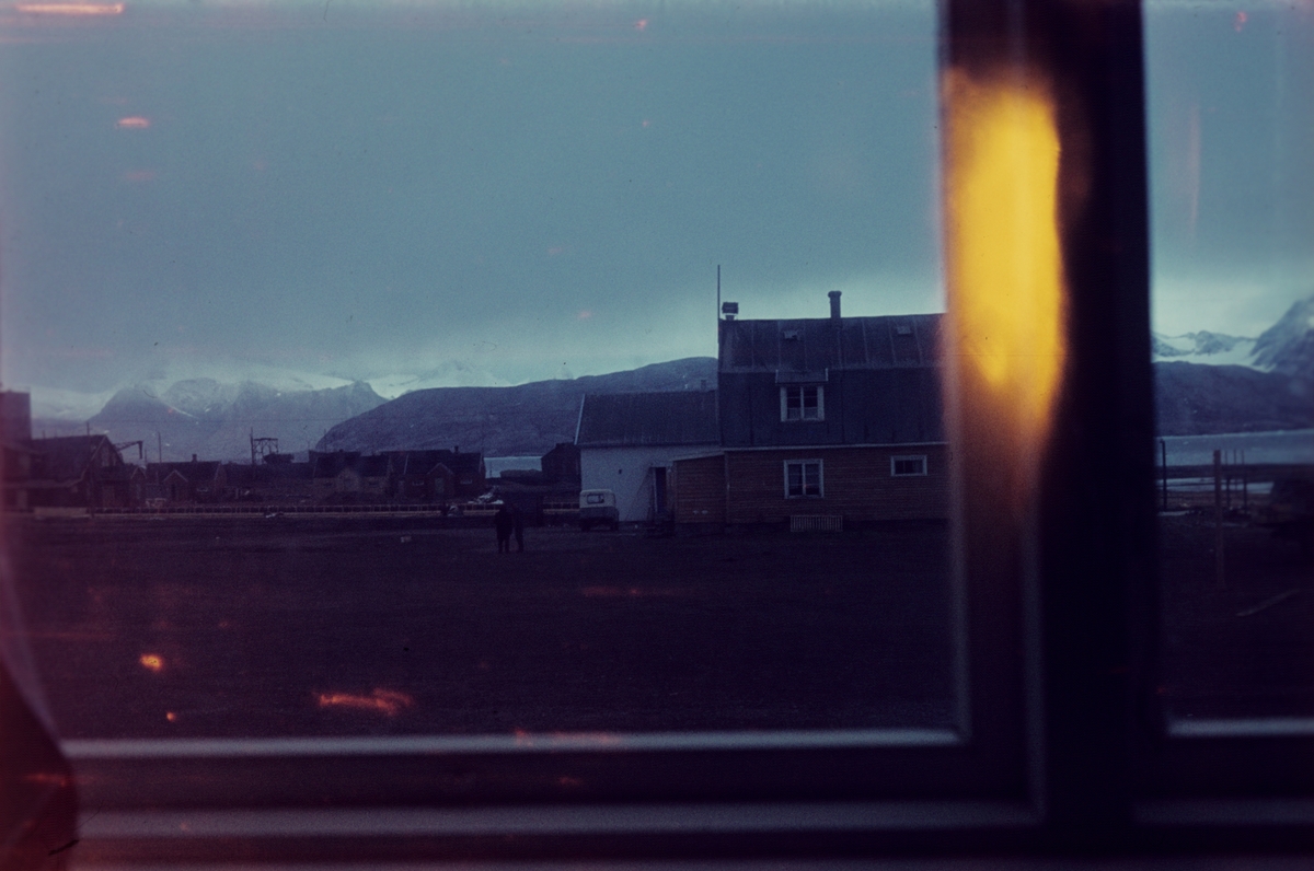 En utsikt til Ny-Ålesund fra et vindu.