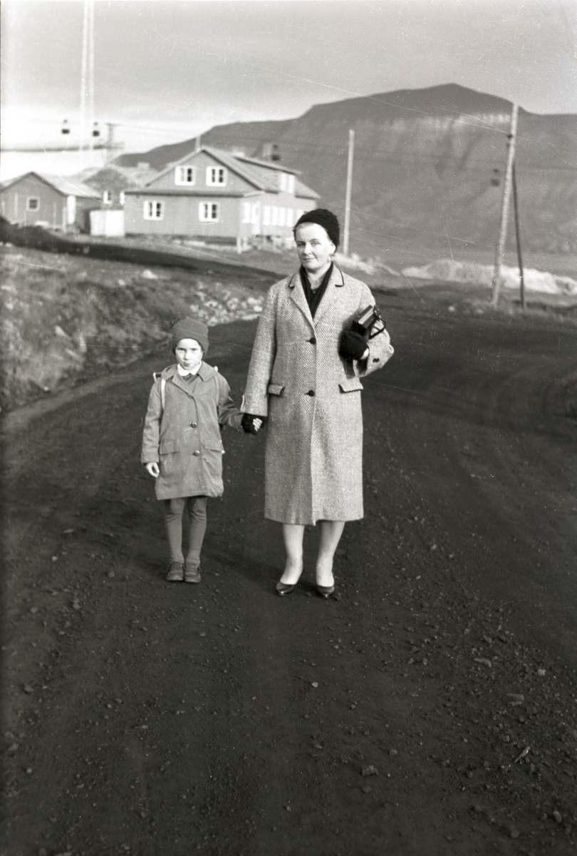 Kari Wendt med sin mor Anna Wendt  på vei til første skoledag på Huset høsten 1960.  Gamle Telegrafen i bakgrunnen, hvor de bodde i den nederste delen. Carl A. Wendt var sysselmannsfullmektig 1960/61.