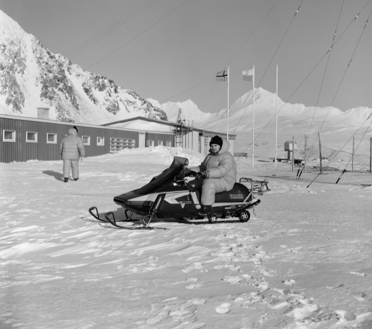 Forsker på snøskuter foran den polske forskningsstasjon.