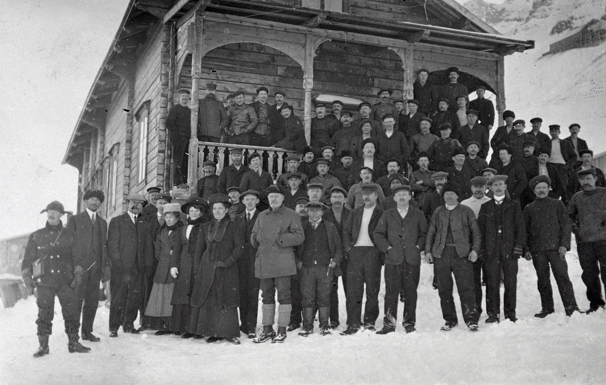 Gruppe av mennesker foran butikken i Longyearbyen, tidligere turisthytta på Hotellneset..