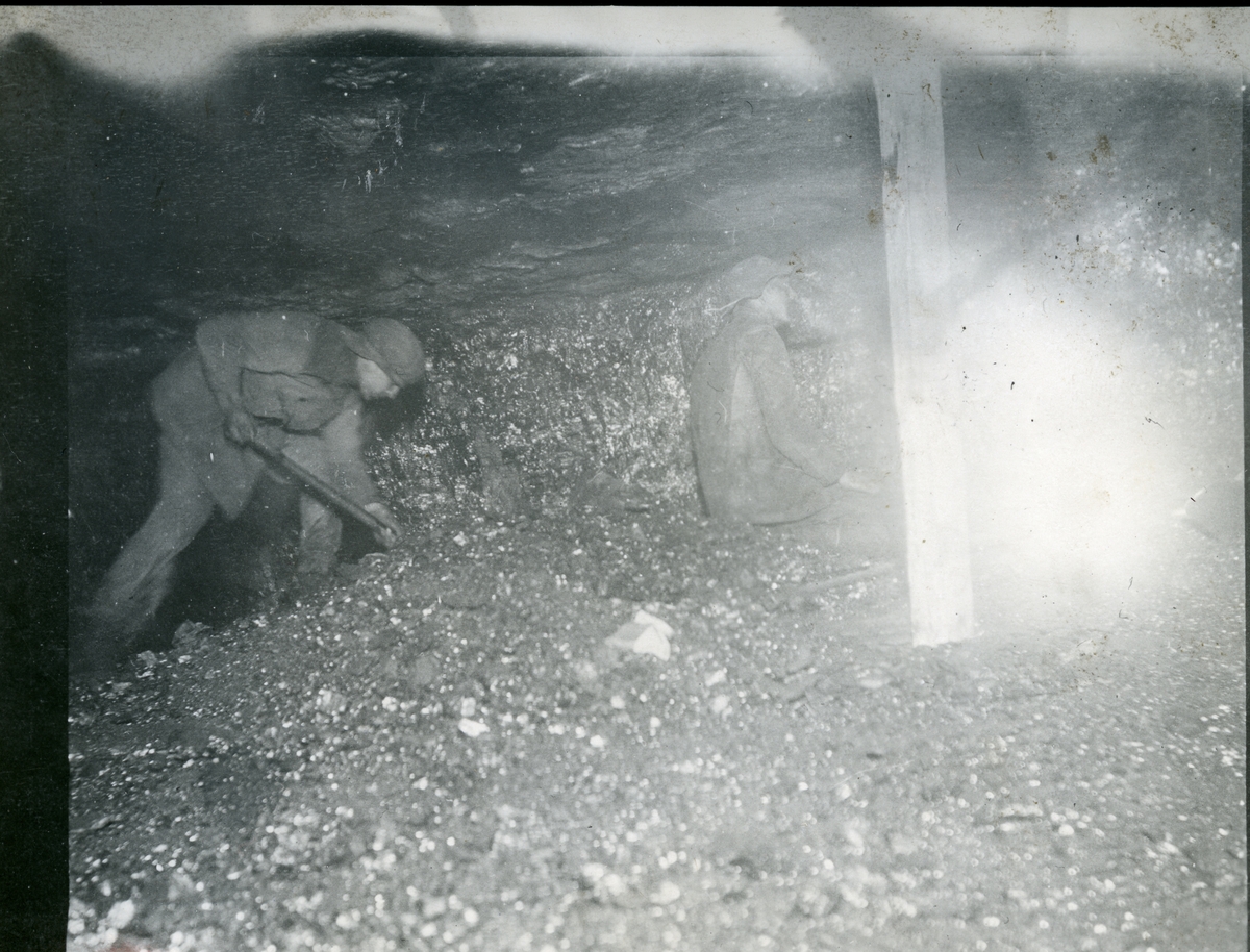 To menn (muligens Bay og Sandnæs) på arbeid inne i en gruve på Svalbard  i 1914. Bildet er fra bildesamlingen til Jens Kristoffer Bay, som var  sjef for en overvintringsekspedisjon på Svalbard vinteren 1914/15.