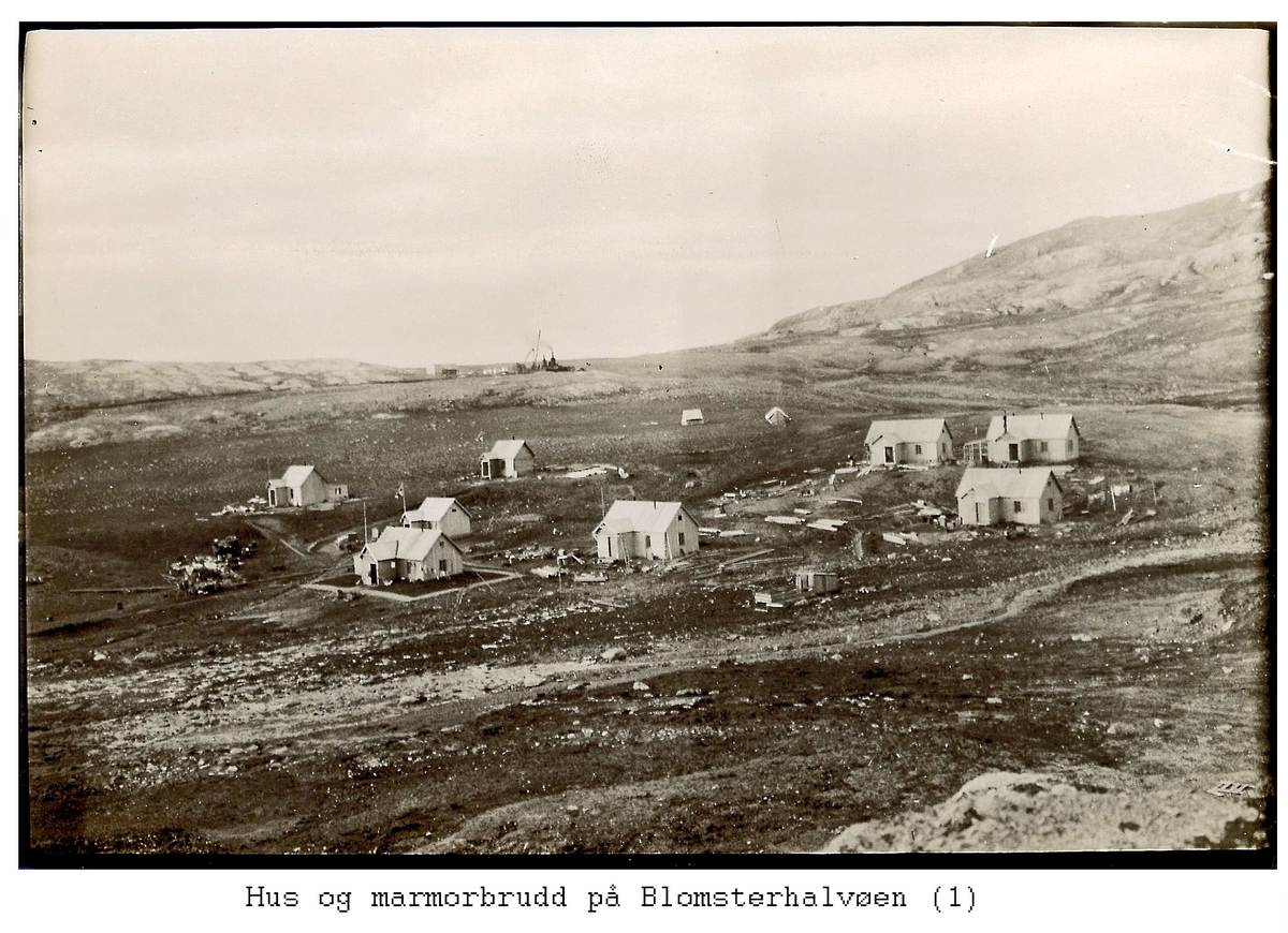 Alf Frantzens fotosamling:  Åtte hus og to telt i Northern Exploration Company’s marmorbrudd i London på Blomstrandhalvøya. Marmorbruddet bakerst mot himmelen. 1912. (De to bakerst til venstre står ennå, de fire til høyre ble flyttet til Ny-Ålesund tidlig på 1950-tallet).