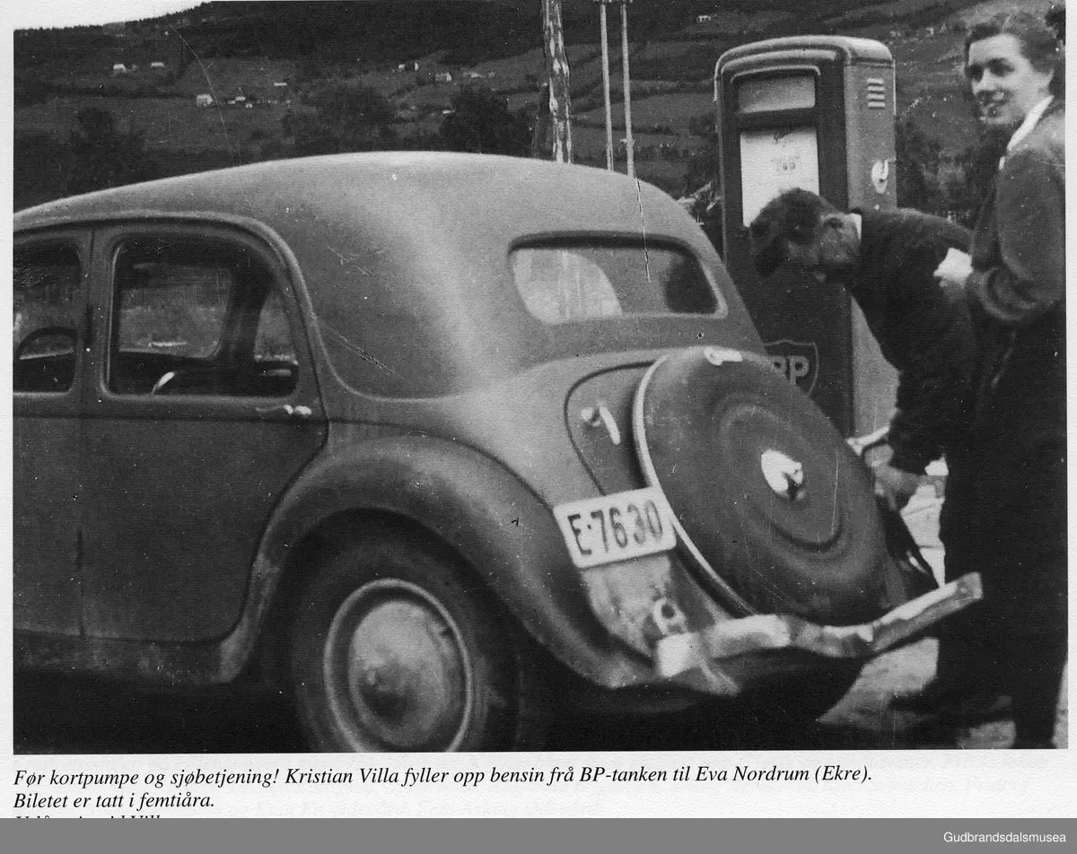 Før kortpumpe og sjølvbetjening! Kristian Villa fyller opp bensin frå BP-tanken til Eva Nordrum (Ekre). Biletet er tatt i femtiåra. 1950
Utlån: Astrid Villa
Bilen er ein Citroën.
Vågåkalenderen 1995, utgjevar: Vågå Kameraklubb