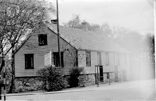 Det sk Wallmanska huset med rum för resande i hörnet Västra Vallgatan-Norra Hamnvägen i Järnvägsparken. Bilden tagen mot nordväst. Här förmodas fotograf Birger Sjöberg (1835-1875) ha haft sin ateljé. Fototid: 1930-tal.