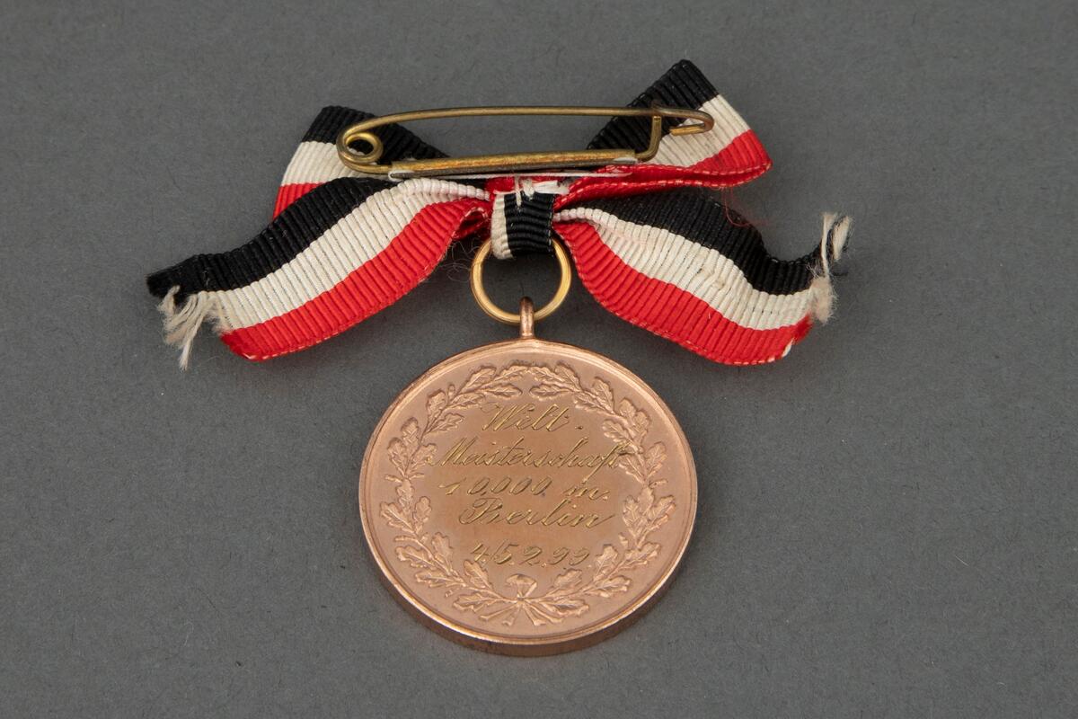 Rund medalje i bronse med opphøyet rand og punslet dekor. På avers er det en laurbærkrans, en hornskøyte og et rundt felt med Berlins våpen. På revers er det en laurbærkrans og gravert tekst. Medaljen er festet til en nål med sløyfe i ripsbånd med hvite, røde og svarte striper.