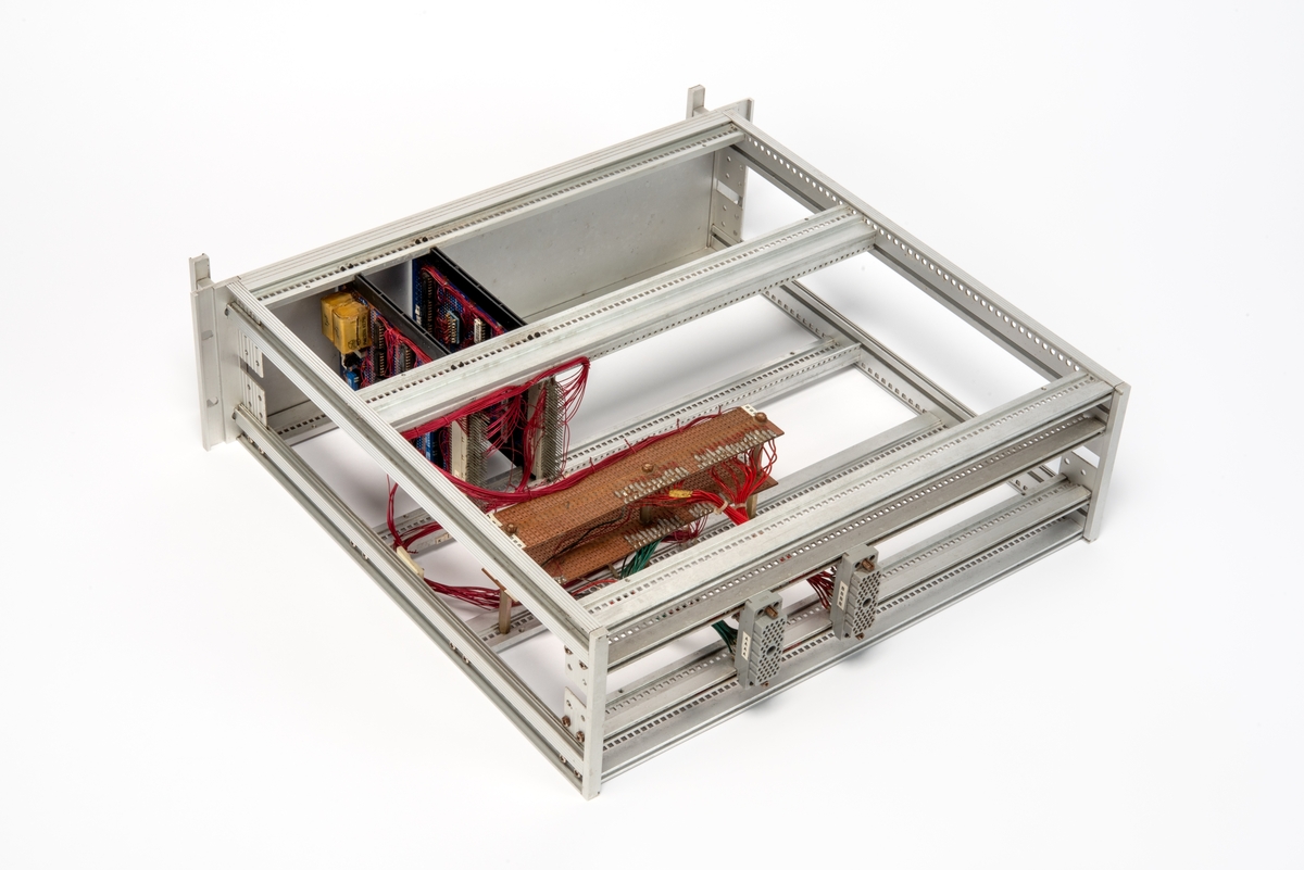 Innebygd enhet med kretskort og multikontakter.
Enheten er skrudd fast til seksjonen, men kan demonteres og løftes ut ved hjelp av to håndtak foran på panelet.