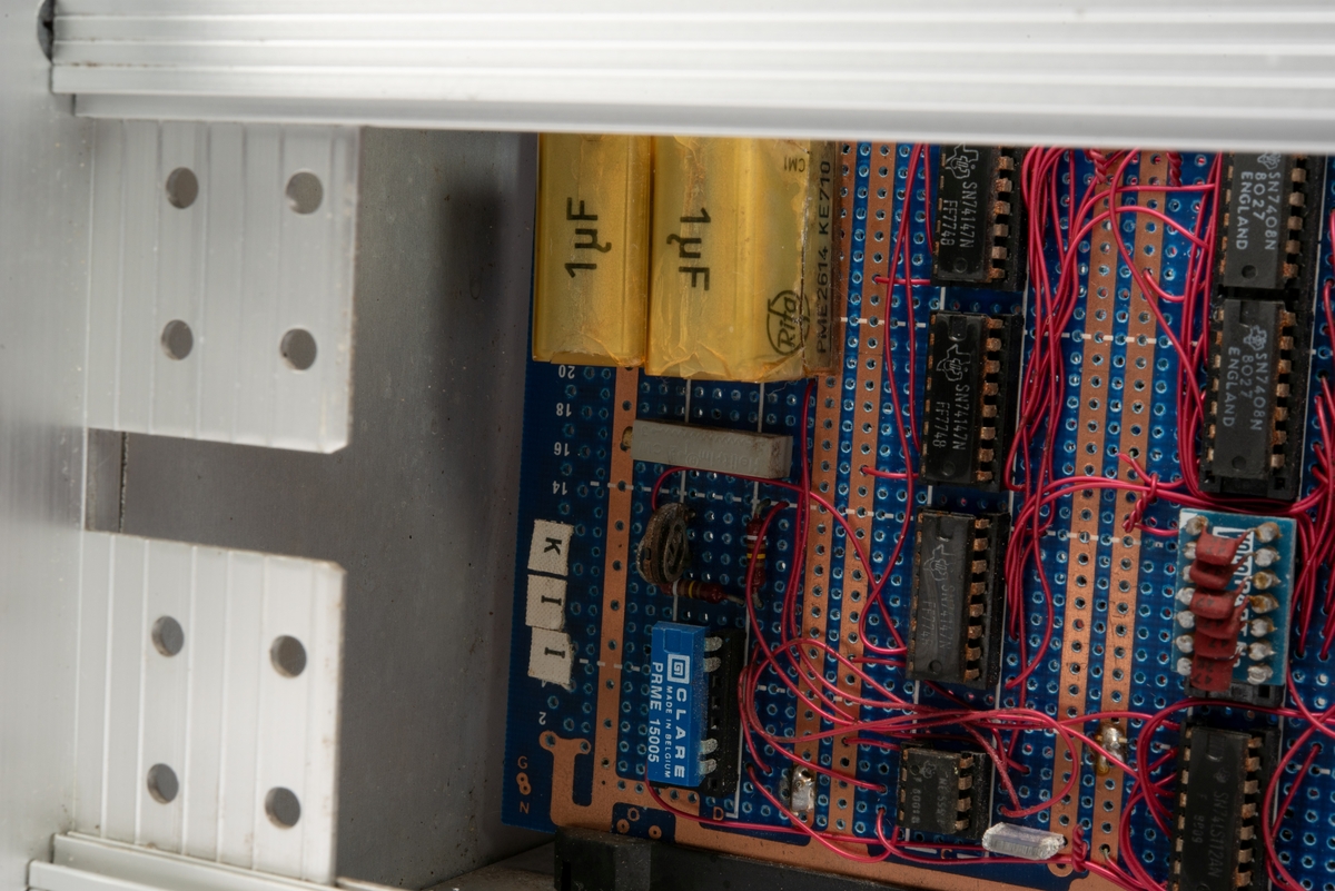 Innebygd enhet med kretskort og multikontakter.
Enheten er skrudd fast til seksjonen, men kan demonteres og løftes ut ved hjelp av to håndtak foran på panelet.