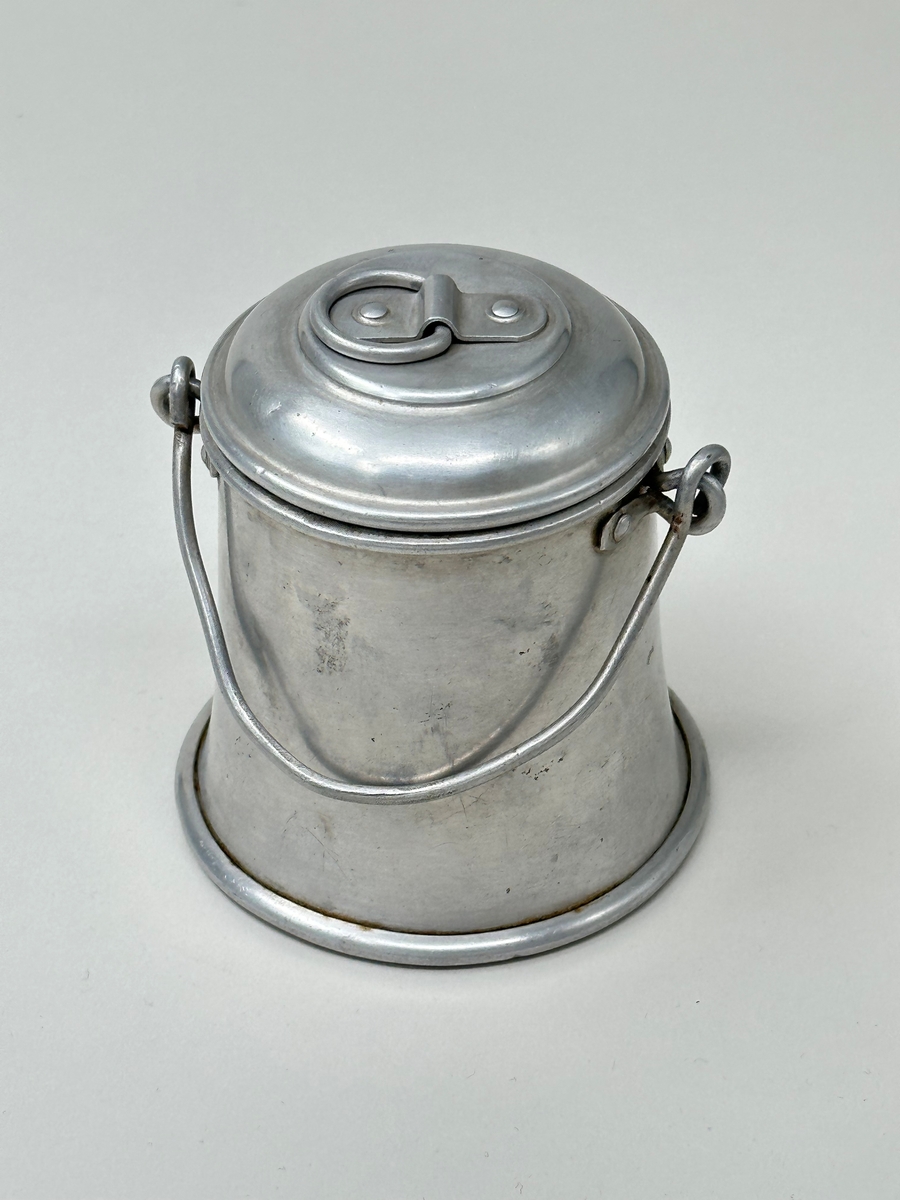 Leksak, mjölkhämtare av aluminium. Behållare (A) med bygelhandtag och lock (B) med ringgrepp.