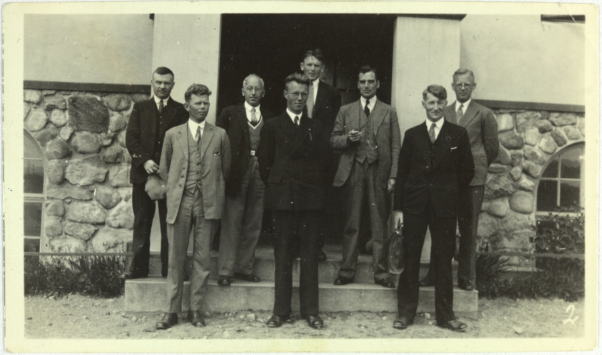 Skolebilde frå Bryne, 1933, med åtte menn i dress, tilsette ved Rogaland landsgymnas på Bryne. Framme frå venstre: Tønnes Skjæveland, Ragnar Houg (vikar), Ola Nordsletten. Bak frå venstre: Jørgen Ødegård, Magnus Jonsbråten, Bjarne Undheim, Mikjel Haugstveit (truleg), Anders Ljono (vikar).