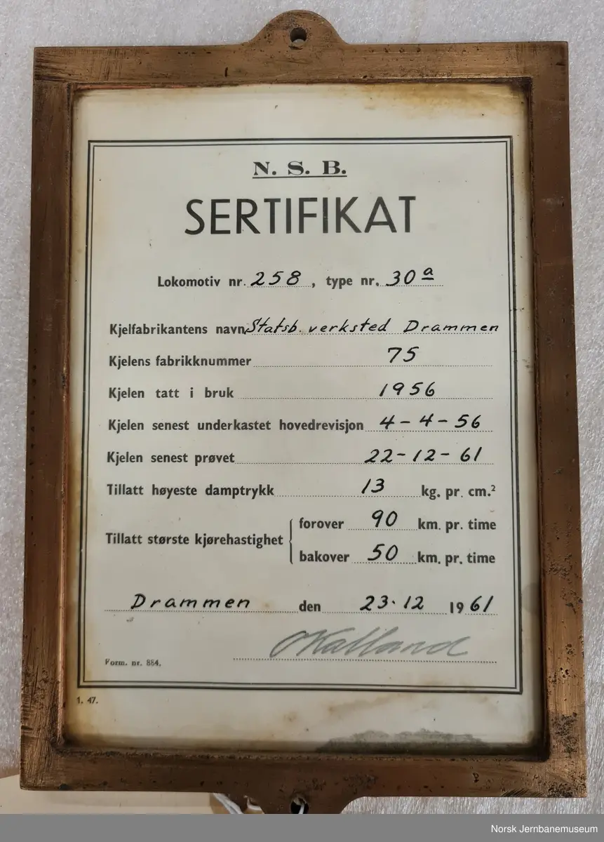 Sertifikat for godkjent kjel innrammet i metall og glass.