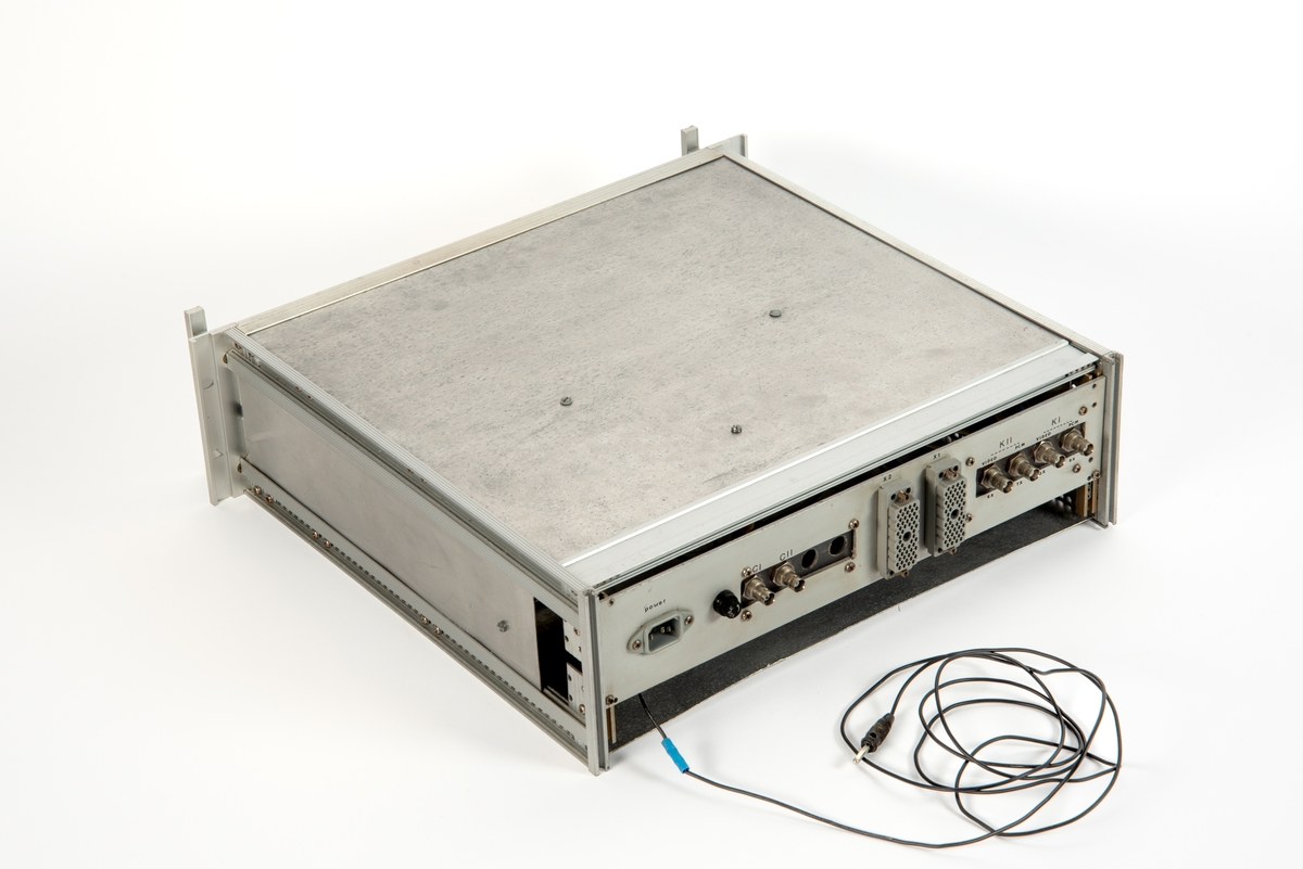 Innebygd enhet med deksel på oversiden. Foran på panelet er det festet et ark med informasjon om nye innstillinger for dybdemåling. Informasjonen er skrevet for hånd, og arket er merket med Frigg og datert 24. juli 1981.
Enheten er skrudd fast til seksjonen, men kan demonteres og løftes ut ved hjelp av to håndtak foran på panelet.