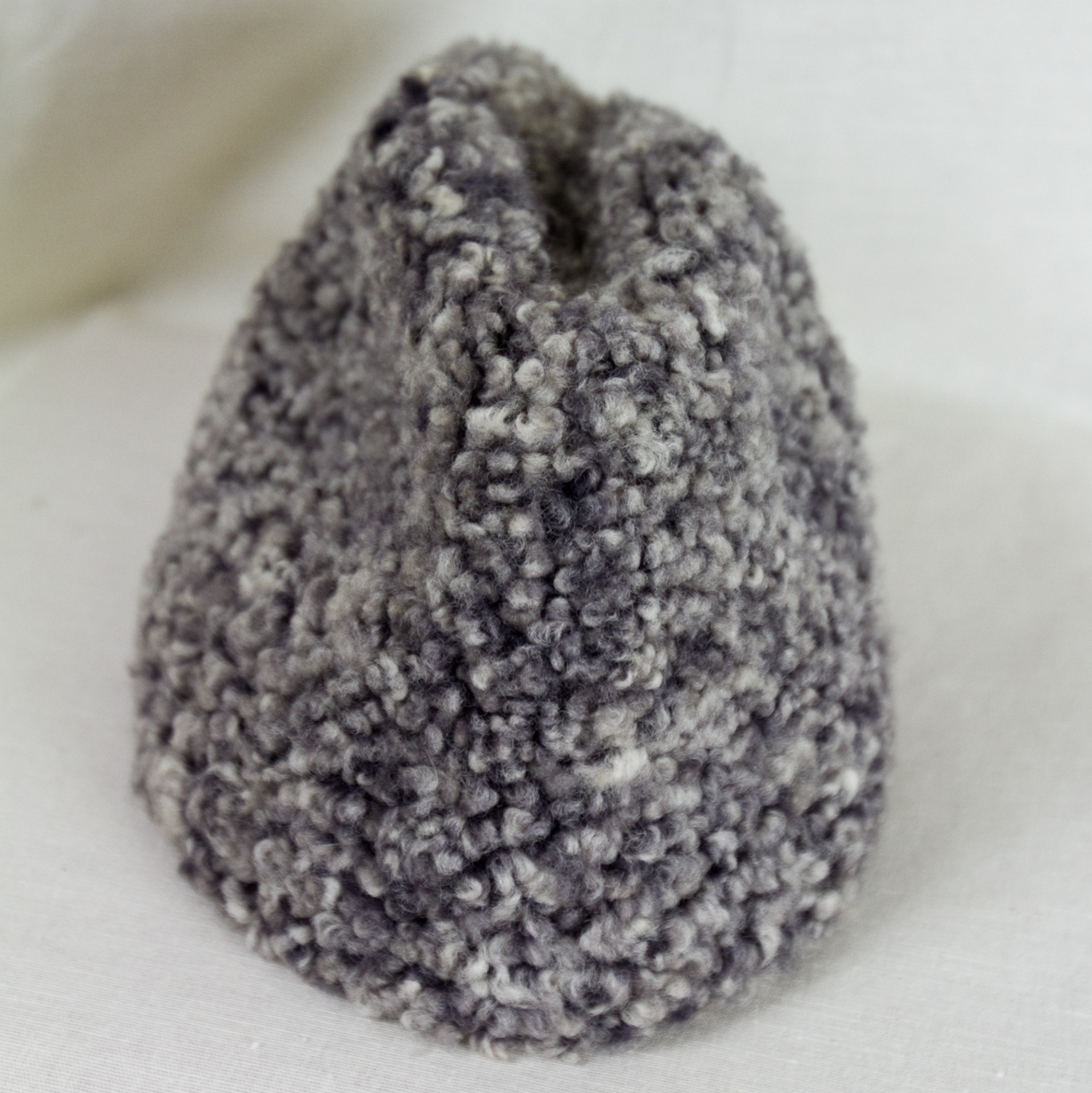 Herrmössa, vintermössa i grå skinnimitation (krimmer). Hög stukad kulle.