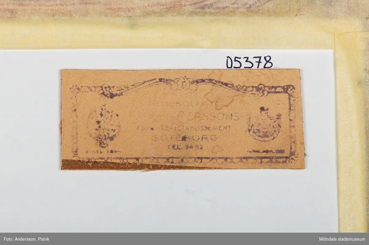 Ett inramat fotografi som föreställer prinsen av Wales, Prins George och dåvarande kronprins Gustav VI Adolf vid ett besök på Papayrusfabriken i Mölndal år 1932. Fotografiet har en beige passepartout med en svagt tonad grå/beige bakgrund föreställande en siluett av området vid papyrusfabriken.
Under fotot finns texten: Their Royal Highnesses The Prince of Wales, Prince George and The Crown Prince of Sweden visiting Papyrus Paper Mills
October 11TH 1932. Längst upp på tavlan står det Papyrus Paper Mills
Mölndal Sweden.
Bilden har en brun medeltjock konkavt formad träram.
På baksidan av tavlan finns ett emblem som anger: Aktiebolaget Ferm & Persson förgyllerietablissement.