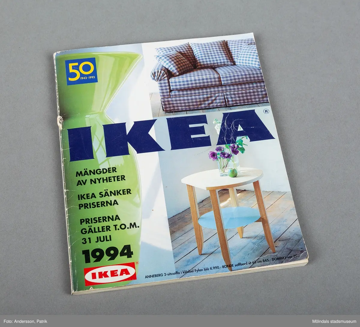 En Ikeakatalog från 1994. På framsidans övre högra hörn finns en bild på en blåvit rutig soffa. Längst ned till höger finns ett vitt runt mindre bord med två blomvaser.
Texten IKEA står mitt på sidan i mörkblå färg. Längst uppe till vänster finns en blå ruta som innehåller siffran femtio i gul färg.
På katalogens baksida finns en bild på vita matallrikar. Dessa heter Plakett tallrikar och en stor siffra visar att tallrikarna kostar fem kronor styck.
Ikea är ett svenskt varumärke som grundades 1943 av Ingvar Kamprad som ett postorderföretag. Företaget ägs numera av en stiftelse i Nederländerna. Huvudkontoret ligger numera i Leiden i Nederländerna.