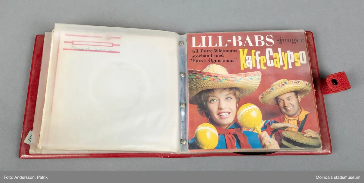 En röd väska i vinyl, som innehåller 8 singlar från 1960-1970 tal. Väskan har ett handtag och Flera av dem är reklamskivor ( Skogaholms bröd), Instant Premiär kaffe). Singlarna ligger i plastfack som fästs med tryckknappar på väskans/ fodralets pärm.  Väskans ägare Margareta Andersson (1950-2019) som gift Maragareta Kanter, har skrivit sin namnteckning på skivomslagen. Singeln av musikern Emele Ford åtfäljs av en autograf och tre svartvita tidningsurklipp föreställande artisten. Dessutom ligger 6 st tunna reklamsinglar löst i fodralet.
På väskans omslag står det Stones handskrivet med svart penna.
EP-skivor eller även kallade vinylskivor är gjorda av vinylplast. De var dominerande under 1950- 1990 som uppspelningsmedium. De första vinylskivorna tillverkades på 1930-talet. Det stora genombrottet kom först 1948, då man lanserade den första LP-skivan. På 1970-talet började man ge ut vinylskivor med stereoljud.
Vinylen har återigen börjat bli populär och säljs stort på andrahandsmarknaden.