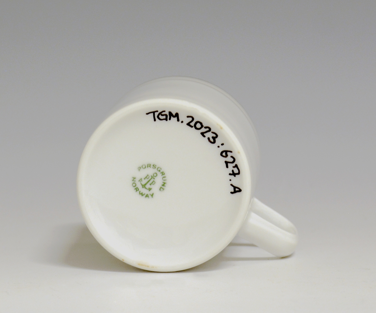 Kopp av porselen med hvit glasur. Dekorert med to enkle striper i platina med et grått bånd i mellom øverst på korpus.
Modell: Saturn
Dekor: Platina
