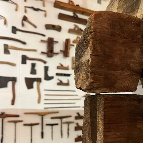 Laftestokk og økser utstilt på vegg