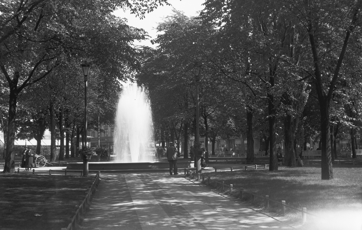 Mennesker spaserer rundt fontenen på Olaf Ryes plass.